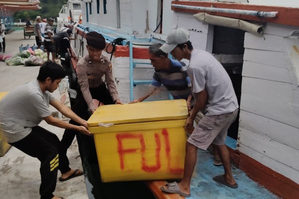Polisi Baik Polsek Kepulauan Seribu Utara Bantu Warga Angkut Cooler Box Ikan Besar di Dermaga Pulau Kelapa