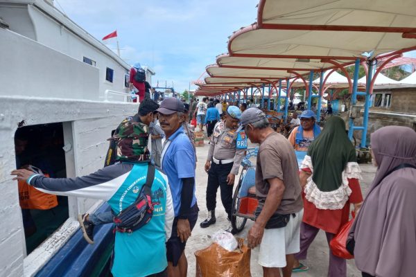 Polisi Baik Polsek Kepulauan Seribu Utara Bantu Penumpang Turun dari Kapal di Pulau Harapan