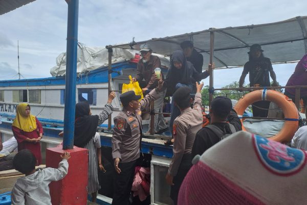 Polisi Baik Polsek Kepulauan Seribu Utara Bantu Penumpang Turun dari Kapal di Dermaga Pulau Panggang